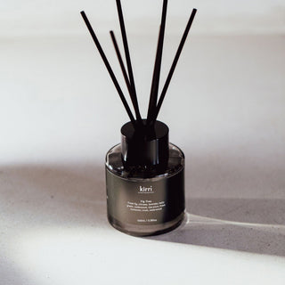 kirri fig tree reed diffuser with fresh black reeds on a stone plinth